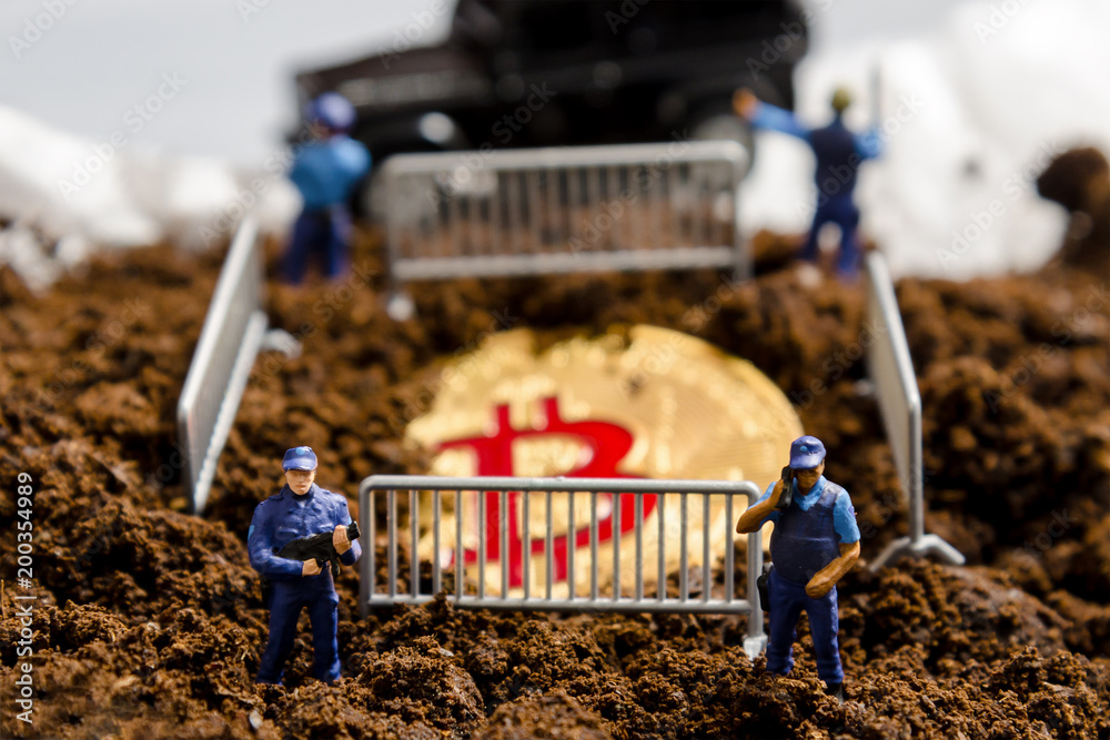 miniature policeman officers stand watch over bitcoin in fence. digital virtual cryptocurrency money blockchain concept