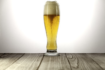 long glass of beer with foam