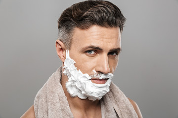 Poster - Mature man standing isolated with shaving cream on face.