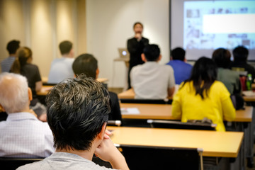 audience listening speaker who standing in front of the room at the conference hall, business and en