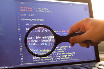 PHP back-end code zoomed through a magnifier. Computer programming source code lookup. Abstract screen of web developer. Code is created by myself.