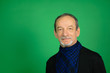 © Ольга  - Portrait of a mature man on a green background. Black sweater, blue scarf around his neck, benevolent facial expression, gray-haired man, well-trimmed beard
