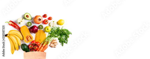 Healthy food background. Healthy vegetarian food in paper bag pasta, vegetables and fruits on white. Shopping food concept. Long format with copy space © missmimimina