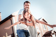 © zinkevych - Like a bird. Caring unshaken pleasant father standing on the yard smiling and supporting his daughter.