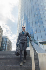 brutal man in a jacket and sunglasses on the street