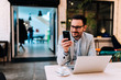 © bnenin - Portrait of smiling man looking at smartphone at the cafe.