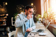 © bnenin - Businessman with bandaged hand drinking coffee in a cafe.