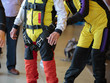 Skydiver Instructor Helps Apprentice to Tie Security Belt on His Parachutist Suit