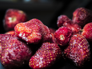 Wall Mural - close up raw fresh frozen strawberries on black dark background