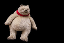 A Staffed Grumpy Teddy Bear On A Black Background