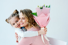 Portrait Of Smiling Daughter With Bouquet Of Flowers And Happy Mother Hugging Each Other, Happy Mothers Day Concept