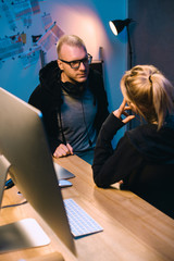 Wall Mural - couple of hackers talking to each other at workplace in dark room