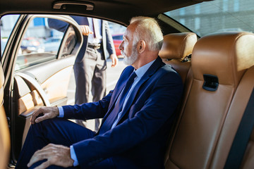 Senior business man sitting in his limousine. Business concept. 