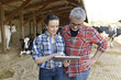 © goodluz - Couple of farmers in cowshed connected with tablet