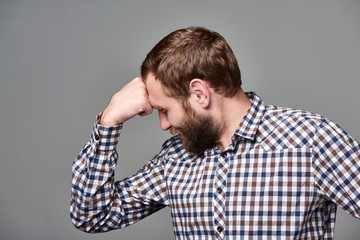 Portrait of thinking business man with fist on forehead