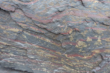 Surface of black rock with red stripes