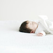 © amanaimages - 布団で寝ている赤ちゃん