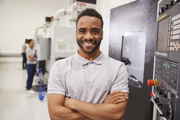 Wall Mural - Portrait Of Male Engineer Operating CNC Machinery In Factory