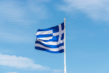 Flag of Greece on flagpole against the blue sky