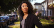 © rocketclips - Curly-haired young African lady standing around outdoors in suburban setting