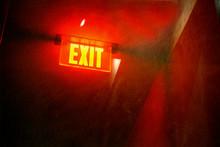 Aged And Worn Exit Sign At Night
