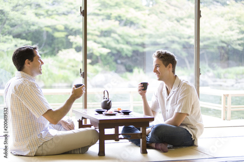 お茶を手に話しをする２人の外国人観光客 Kaufen Sie Dieses Foto