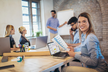 business colleagues in conference meeting room during presentation. businesswoman using laptop and l