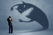 © ra2 studio - Business man afraid of his own shadow monster concept on grungy background