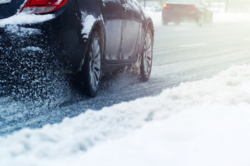 closeup of a car wheel going through snow