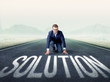 © ra2 studio - Young determined businessman kneeling before solution text