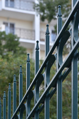 Iron fence against the background of a residential, tall building