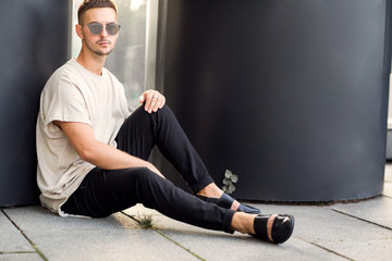 fashion guy posing in sunglasses on sunset