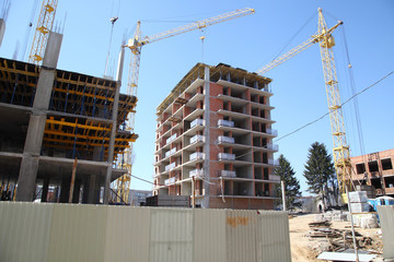 Construction site with cranes on sky background. Construction of a residential multi-storey building. New residential area