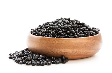 Raw  black beans in wooden bowl isolated on white