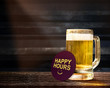 Happy Hours Promotional Concept. Glass of Beer on the Wooden Table in Bar with Paper Note and Word
