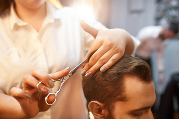 Young handsome bearded man visiting barber shop. Barber concept.