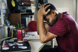 © Rawpixel.com - Teenage boy in a bedroom doing work stressed out and frustrated