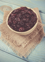 Wall Mural - Dry cranberries fruit in the bowl, on the wood background.