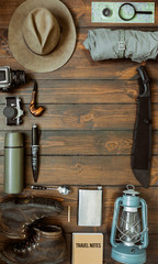 Wall Mural - camping gear including knife, clothes, boots, lantern, camera, hat, map, compass. vertical wanderlus
