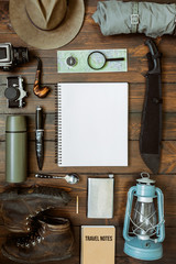 Wall Mural - camping gear including knife, clothes, boots, lantern, camera, hat, map, compass. vertical wanderlus
