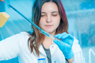 Sticker - Young attractive female scientist  load liquid sample substance probe in the scientific chemical research laboratory