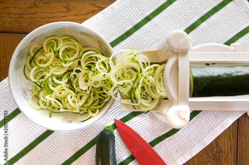 Fotografie, Obraz Spiral zucchini noodles called zoodles prepared in spiralizer kitchen gadget