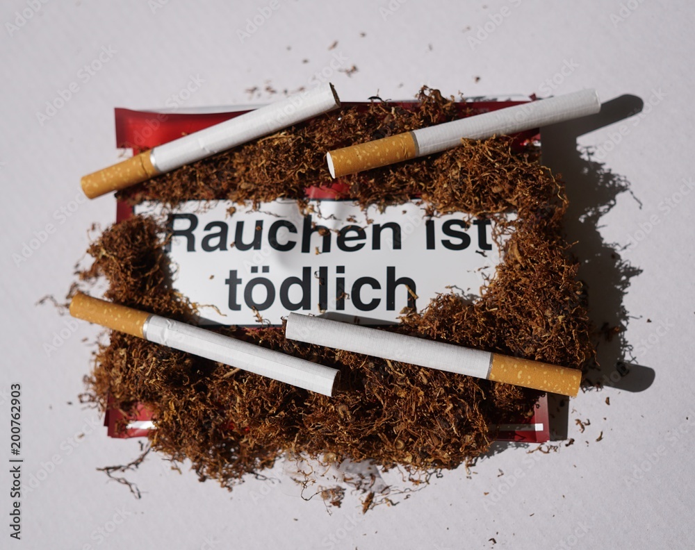 Tobacco addiction concept. Tobacco package warning messages Rauchen ist  tödlich, German for Smoking is deadly Stock Photo