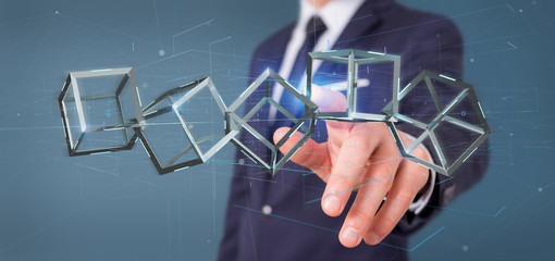 Poster - Businessman holding a 3d rendering blockchain cube isolated on a background