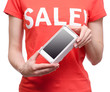 © Kabardins photo - Woman with t-shirt with an inscription sale in hand smartphone mobile phone shop buy discount