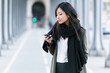© nenetus - Concentrated asian young woman using her mobile phone in the street.