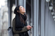 © nenetus - Smiling asian young woman using her mobile phone in the street.