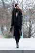© nenetus - Pretty asian young woman listening to music with headphones while walking in the street.