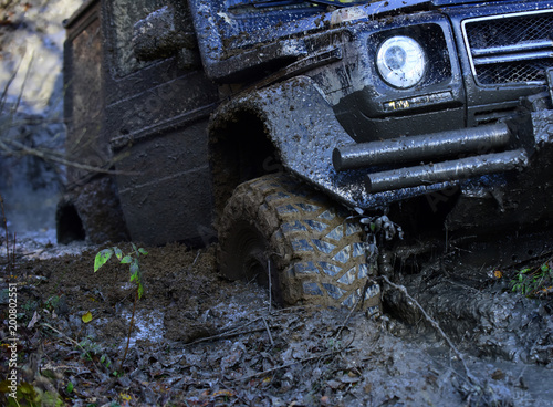 Fotografie, Obraz Wheel in deep rut goes through mud and leaves trail.