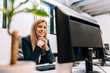 © bnenin - Sucessful smiling businesswoman sitting at the office in front of a computer.